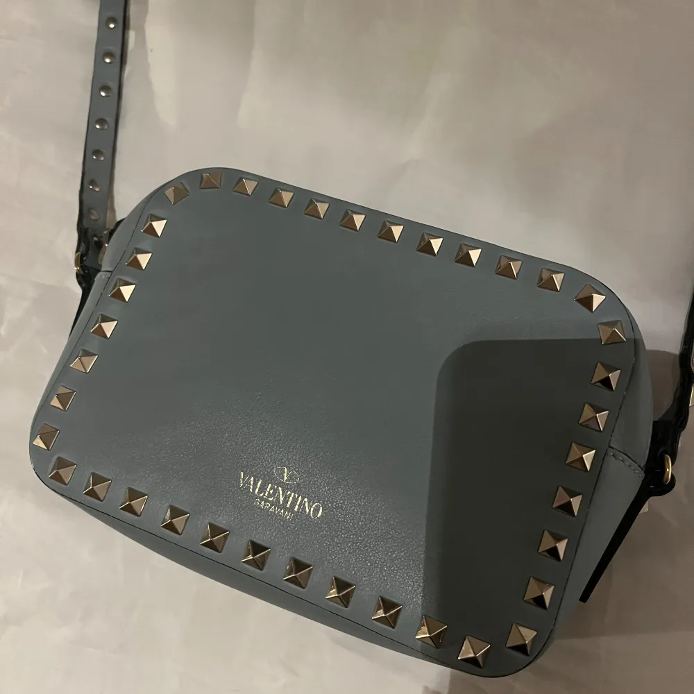 Sååå fin valentino rockstud camera bag. 100% äkta då den har gått igenom en autentisk check! Har fler bilder så hör bara av er🩵🩵 använd mycket men i super fint skick!  Färgen har ljusblå/turkos!. Väskor.