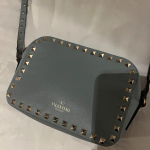 Valentino rockstud camera bag 🩵 - Sååå fin valentino rockstud camera bag. 100% äkta då den har gått igenom en autentisk check! Har fler bilder så hör bara av er🩵🩵 använd mycket men i super fint skick!  Färgen har ljusblå/turkos!