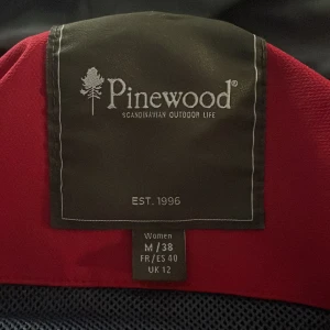 Vandringsjacka Pinewood  - Storlek m/38. Röd, vind och vattentät. Höst/vinterjacka. Den är som ny i skicket! 
