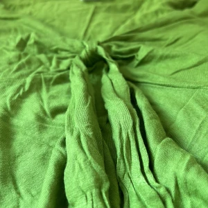 Grön blus  från H&M - Säljer en superfin grön klänning från H&M i storlek 32-34. Det är en urringad design med knytning framtill och korta ärmar med volangdetaljer. Materialet känns mjukt och skönt🫰🏻 