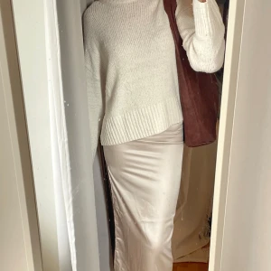BEIGE SATINKJOL - Beige/Champagnefärgad satinkjol från Bershka. Resår i midjan och dragkedja i sidan. Aldrig använd. Storlek: XS Nypris: 329kr