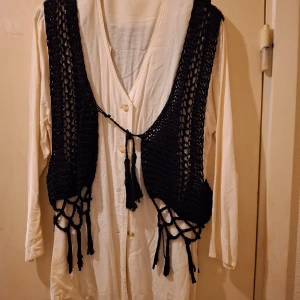 Virkad väst med skjorta strl M - Snygg svart väst med fransar. Västen är virkad och har ett fint mönster. Skjortan är strl M