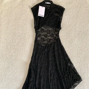 Bershka svart assymetrisk klänning i spets med öppen rygg - Otroligt vacker svart assymetrisk klänning i spets från Bershka med öppen rygg. Ny med prislappar kvar. Slutsåld. 