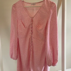Rosa leopardklänning  - Superfin rosa leopardmönstrad klänning från Nelly. Aldrig använd. Knappar i mitten så att man får en fin passform. 