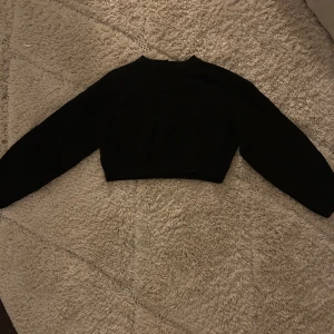 Svart croppad tröja - Snygg svart croppad tröja med långa ärmar. Perfekt för en stilren look.