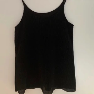 Svart glittrig topp - Snygg svart glittrig linnetopp från Jacqueline de Yong.  Strl S 