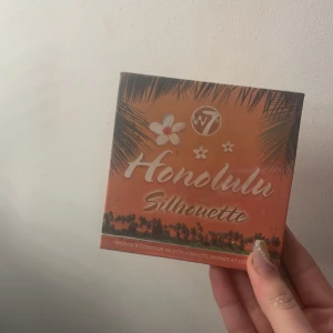 Honolulu Silhouette Bronzer Palette från W7 - Säljer en Honolulu Silhouette bronzer och contour palette från W7. Paletten innehåller fyra olika nyanser för att skapa en solkysst look. Perfekt för att skulptera och definiera ansiktet. Kompakt och lätt att ta med sig.