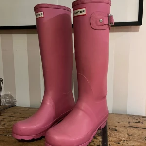 Rosa stövlar från Hunter 💕🤩 - Snygga rosa trendiga stövlar från Hunter med justerbar rem upptill. Perfekta för regniga dagar och ger en färgglad touch till din outfit. Tveka inte på att skriva till mig eller lägga bud!💕