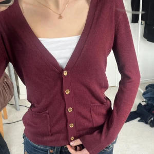 Vinröd kofta från Gina Tricot - Säljer en stilren vinröd kofta från Gina Tricot med knappar framtill. 