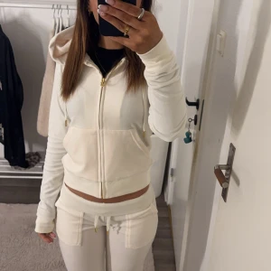 Vit juciy med guld detaljer  - Säljer ett helt nytt  vit juciy set aldrig använt bara testat.  Tröjan har långa ärmar och en praktisk ficka framtill. Perfekt för en avslappnad stil. Byxorna är i storlek xxs och tröjan i xs 