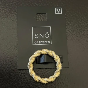 Ring i guld från SNÖ of Sweden.  - Säljer denna superfina guld ringen från SNÖ of Sweden, som är i en flätad design med både guld- och lite silverfärgade detaljer också. Ringen är ej använd, bara provad 1 gång & säljer pga att den är för stor för mig. Storlek M. Orginalpris: 249 kr, men säljer ringen för 160 kr. 