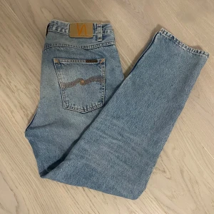 Blå jeans från Nudie - Snygga blå jeans från Nudie, köpte de några veckor sen men inte fått någon användning alls så skicket är som nytt. Passformen är relaxed och passar lite längre i längden. Priset är inte hugget i sten så bud är välkommmna.