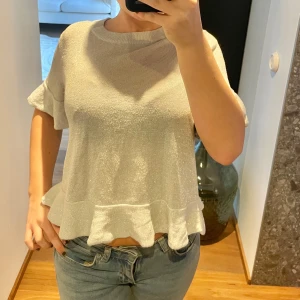 Glittrigt grå topp med volang - Säljer denna gråa glittriga fest/nyårs toppen,  med volangdetaljer.  Skulle säga passar XXS-S beroende på hur tajt och lång man vill ha den. Jag brukar bära XS