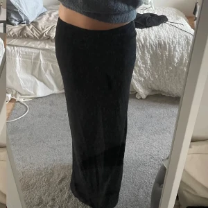 Svart långkjol - Snygg svart långkjol med en enkel och stilren design. Perfekt för en minimalistisk look. Kjolen har en rak passform och är lätt att matcha med olika toppar. Nytt pris 400 och ör använd 1 gång 