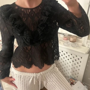 Svart spetsblus från Zara - Snygg svart spetsblus/topp från Zara med volangdetaljer framtill.