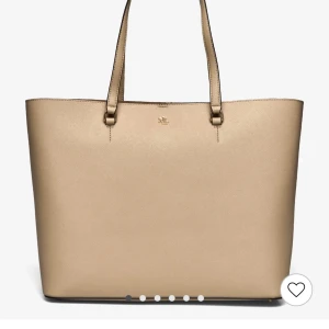 Helt oanvänd Beige Ralph Lauren Väska - NYPRIS: 3700kr. Helt oanvänd kommer i original förpackning, inge post bara uppmötning som vanligt och bara kontant som standard. Snygg beige axelväska från Ralph Lauren i skinn. Väskan har en stilren design med två handtag och en praktisk dragkedja upptill. Perfekt för att bära med sig allt man behöver under dagen. Den har även en ficka på utsidan för extra förvaring.