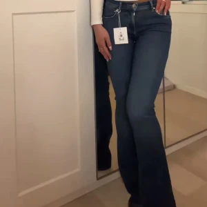 Blå flare jeans - (Första bilden är lånad) Snygga blå flare jeans med låg midja. Längd 31. Sista bilden visar en liten skada på jeansen på en utav benet! Annars i toppen skick🩷