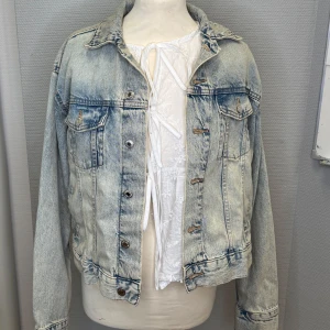 Ljusblå jeansjacka - Säljer en snygg ljusblå jeansjacka i klassisk stil. Jackan har en normal passform med långa ärmar och knappar framtill. Perfekt för vår och sommar, och funkar lika bra till vardags som till fest. Ett måste i garderoben för en cool och avslappnad look!