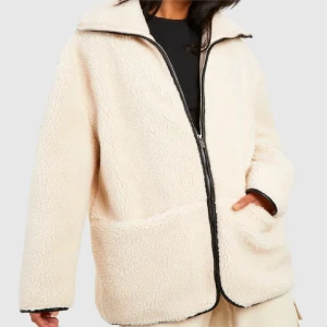 Beige teddyjacka med dragkedja - Mysig beige teddyjacka i mycket bra skick. Den har en dragkedja framtill och stora fickor. Perfekt för höst och vinter när du vill hålla dig varm och stilren. Jackan har en normal passform och långa ärmar. Superfin att ha på sig till vardags eller när du bara vill mysa till det lite extra!