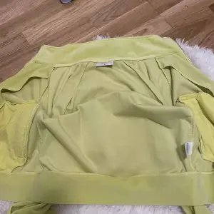 Säljer en superfin gul jacka från Juicy Couture i storlek S. Den har glittriga stenar som bildar texten 'Juicy' på ryggen. Perfekt för att lysa upp din garderob! 💛