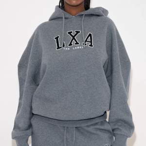 Säljer en snygg grå hoodie från LXA The Label. Den har en stor logga på bröstet och en bekväm passform med långa ärmar och justerbar huva. Perfekt för en avslappnad stil eller mysiga dagar hemma. 🩶