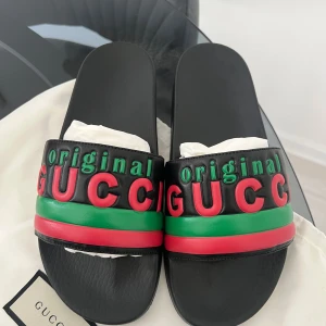 Svarta sandaler från Gucci - Snygga svarta flips från Gucci. Helt oanvända och köptes för 5500kr. Perfekta för sommaren och ger en lyxig touch till din outfit. Kommer med originalpåse.