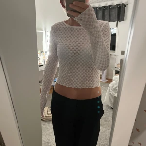 Vit långärmad croppad topp - Säljer en superfin vit långärmad topp som är perfekt att ha på fest. Toppen är i mycket bra skick och ger en stilren look. Passar perfekt till byxor eller kjol!