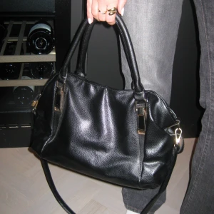 Svart handväska i skinn - Stilren svart handväska i skinn med både handtag och axelrem. Väskan har en praktisk dragkedja och flera fack inuti för bra förvaring. Skriv om ni har några frågor❤️‍🔥❤️‍🔥//YourVintage 