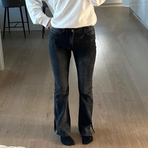 Svarta bootcut jeans med slits - Säljer ett par svarta bootcut jeans från Shein i storlek M. De är i bra skick och har en snygg passform som sitter tight upptill och blir vidare nedtill, med slits. Perfekta för både vardag och fest!💕