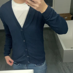 Blå cardigan med knappar - Säljer en mörkblå cardigan. Perfekt för höst och  vinter! Storlek XS men skulle säga att den passar S/M mer. Jag är 177 cm. Priset kan diskuteras ‼️