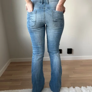 Lågmidjade jeans - Jeans från blue motion med detaljer på bakfickorna. Tjejen på bilden är 165