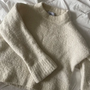 tröja från & Other Stories - Mysig beige tröja från & Other Stories i storlek S. Den är gjord av en mjuk blandning av alpacka, ull och polyamid, perfekt för kyliga dagar. Tröjan har en enkel design med långa ärmar och en rund halsringning. Perfekt för både vardag och mysiga hemmakvällar!