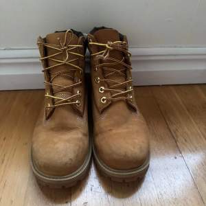 Säljer ett par klassiska bruna Timberland boots i skinn. De har snörning och en robust sula, perfekt för höst och vinter. Skorna är i bra skick med några mindre tecken på användning. Perfekta för både stad och natur!