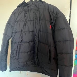 Svart dunjacka Ralph Lauren - Säljer en svart dunjacka från Polo Ralph Lauren i mycket bra skick.  Inte använd alls!  Skriv för mer bilder! Du står för frakten!!!