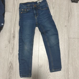 Blå jeans från Drew - Säljer ett par snygga blå jeans från Drew i bra skick. De har en klassisk femficksdesign och är perfekta för vardagsbruk. Jeansen har en normal passform och är tillverkade i ett slitstarkt denimtyg. Perfekta för både höst och vår!