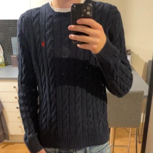 Mörkblå kabelstickad tröja från Ralph Lauren - Säljer en snygg mörkblå kabelstickad tröja från Ralph Lauren. Som är i jätte fint skick. Köpt från ralph lauren för 2200kr. Om ni vill diskutera pris tveka inte på att skriv!