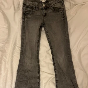 Lågmidjade grå bootcut jeans  - Säljer nu mina  fina grå lågmidjade jeans från gina young. De är lite slitna längst ner vid kanten men inget man tänker på, annars bra skick. Skriv om ni har några frågor🤍🤍
