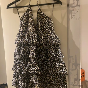 Leopardmönstrad klänning med volanger - Säljer en superfin leopardmönstrad klänning med volanger. Den är axelbandslös och perfekt för en festlig kväll. Klänningen har en lös passform och är gjord i ett lätt och bekvämt material. Perfekt för sommaren eller en utekväll!