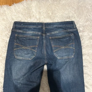 Mörkblå jeans med bootcut - Säljer ett par snygga mörkblå jeans i bootcut-stil. De har dekorativa sömmar på bakfickorna och är knappt använda💕