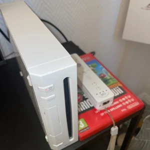 Nintendo Wii med spel - Säljer ett helt Nintendo wii med 2 konsoller, en ratt och alla tillhörande sladdar. + 2 spel (super mario bros) och (mario cart). Kan släppa spelen separat. Pris kan diskuteras.