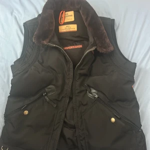 Svart dunväst med pälsdetaljer - Säljer en svart parajumper väst i storlek S i mycket bra skicka, svårt att få tag på. Äkta! 