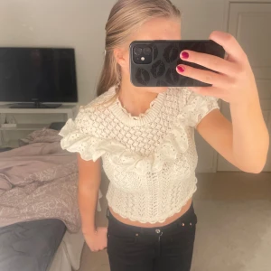 Vit stickad topp med volangdetaljer - Säljer en superfin vit/beige stickad topp med volanger från Zara. Perfekt för vår och sommar! Passar både till vardags och festliga tillfällen. 