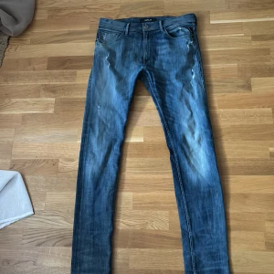 Blå jeans från Replay - Säljer ett par nästan helt nya jeans från Replay (Jondrill) i storlek 32. Sjukt snygg tvätt och några diskreta slitningar. Perfekta för både vardag och fest! 🕺nypris runt 1800