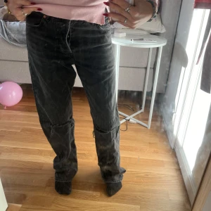 Svarta jeans från Junkyard med hål vid knäna - Säljer ett par svarta jeans i bra skick. De har en klassisk femficksdesign och är lågmidjade med en straight passform. De har detaljerade hål vid knäna. Perfekta för både vardag och fest! 🖤