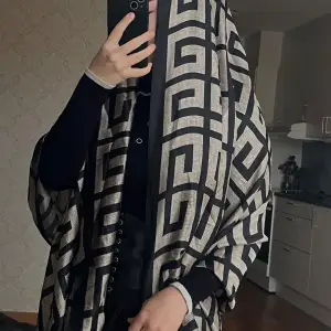 Säljer en elegant och stilren hijab i svart och beige med ett geometriskt mönster. Perfekt för att ge din outfit en sofistikerad touch. Helt ny🛍️