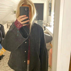 Svart jacka från NORR - Säljer en snygg svart/grå jacka från NORR som har lappen kvar och aldrig använts. Jackan har en normal passform med vida ärmar och knappar framtill. Perfekt för höst och vår, och funkar både till vardags och fest. Materialet känns slitstarkt och stilrent. Passar perfekt över en stickad tröja eller t-shirt. Orginal pris 1699kr