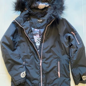 Svart parkajacka med avtagbar huva - Säljer en svart parkajacka från woxo ii mycket bra skick. Jackan har en mysig pälsfodrad huva och praktiska dragkedjor i rosa. Perfekt för kalla vinterdagar med sin långa ärm och varma material. Passar både till vardags och lite finare tillfällen. Ej urtvättad som det ser ut på bilden.