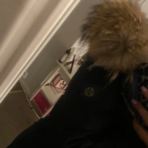 hollies jacka - Snygg svart hollies med huva och pälsdetaljer. Jackan har dragkedja och är äkta päls och äkta märke. Säljer den för att den sitter lite för stor för mig. Perfekt för kyliga dagar och knappt användt, ingen fel eller skada på jackan. kan även diskutera om priset privat, skriv jättegärna privat för frågor.