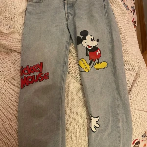 levi’s x disney mickey mouse jeans - snygga midrise ljusblå jeans från ett samarbete mellan levi’s och disney. jeansen är i en klassisk 501 modell, ljusblåa i färgen, och knappt använda! 