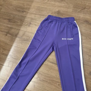 Lila Palm Angels byxor - Säljer nu mina  lila Palm Angels byxor i storleken M men passar även S. Riktigt varma o bekväma byxor nu för vintern. Dom är knappt använda och kondition är 9/10. Modellen är 173 cm. Bara att höra av sig vid frågor eller mer bilder! Pris går att diskutera vid snabb affär✅